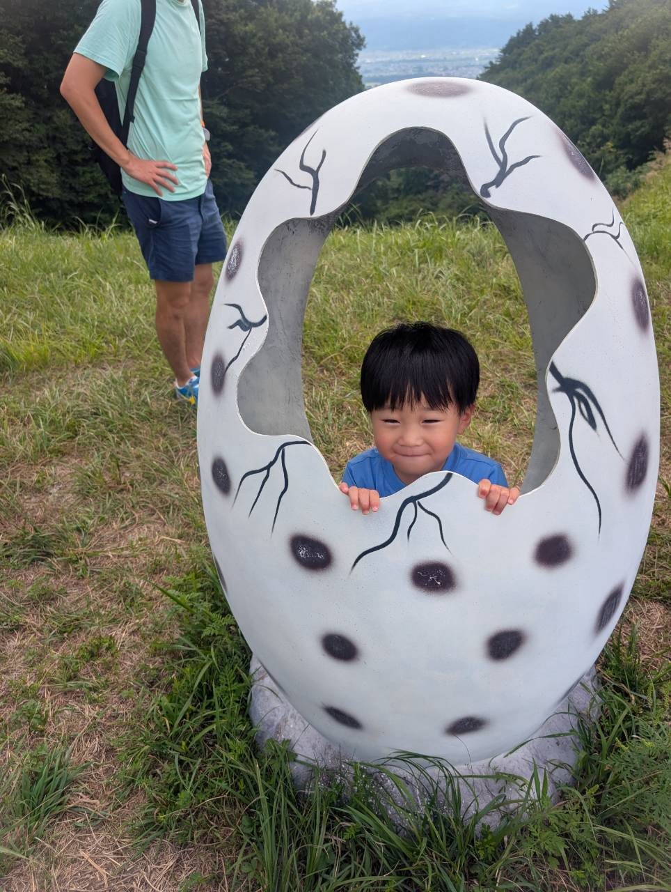 たまごのオブジェから顔を出す男の子