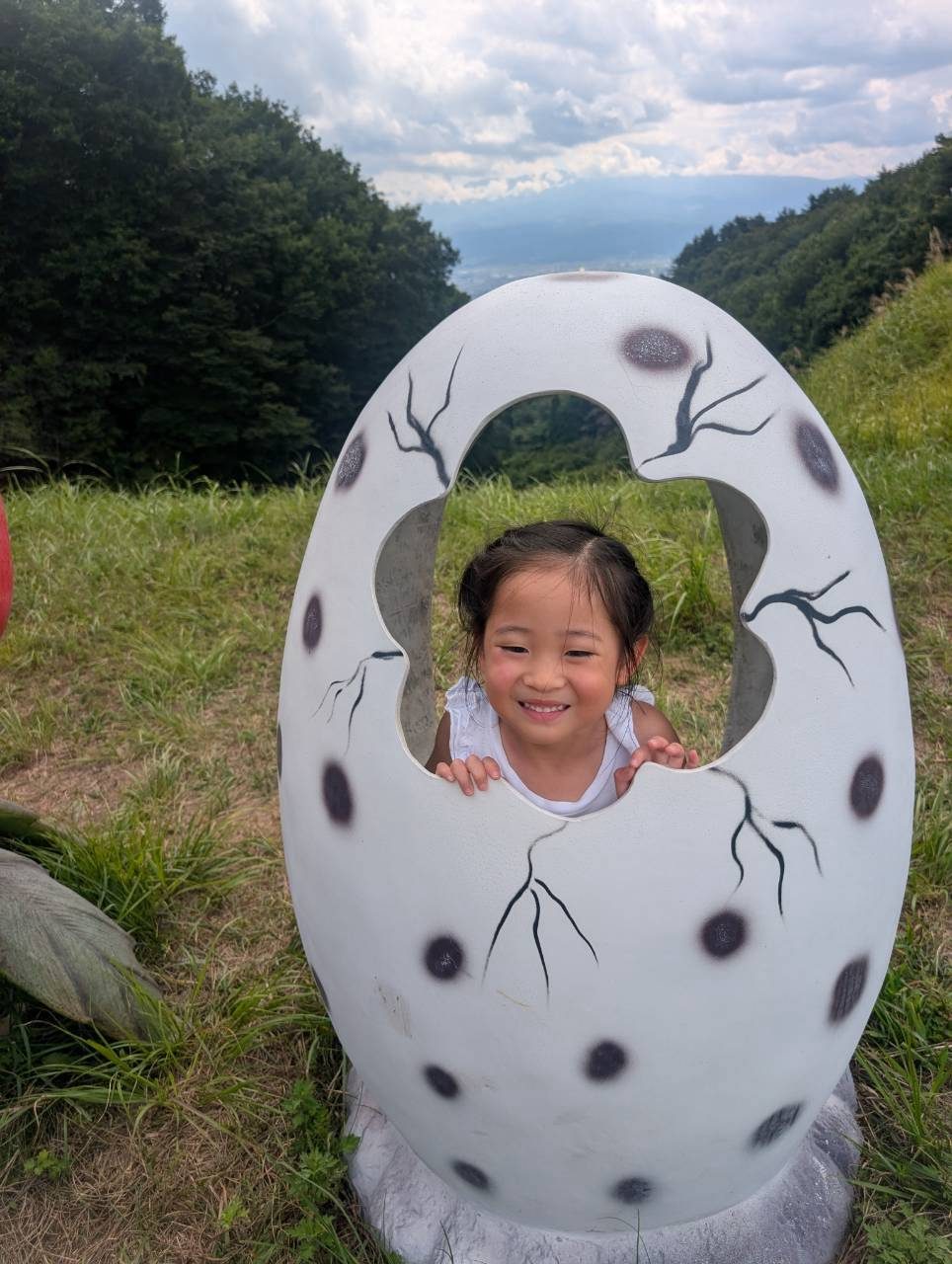 たまごのオブジェから顔を出す女の子