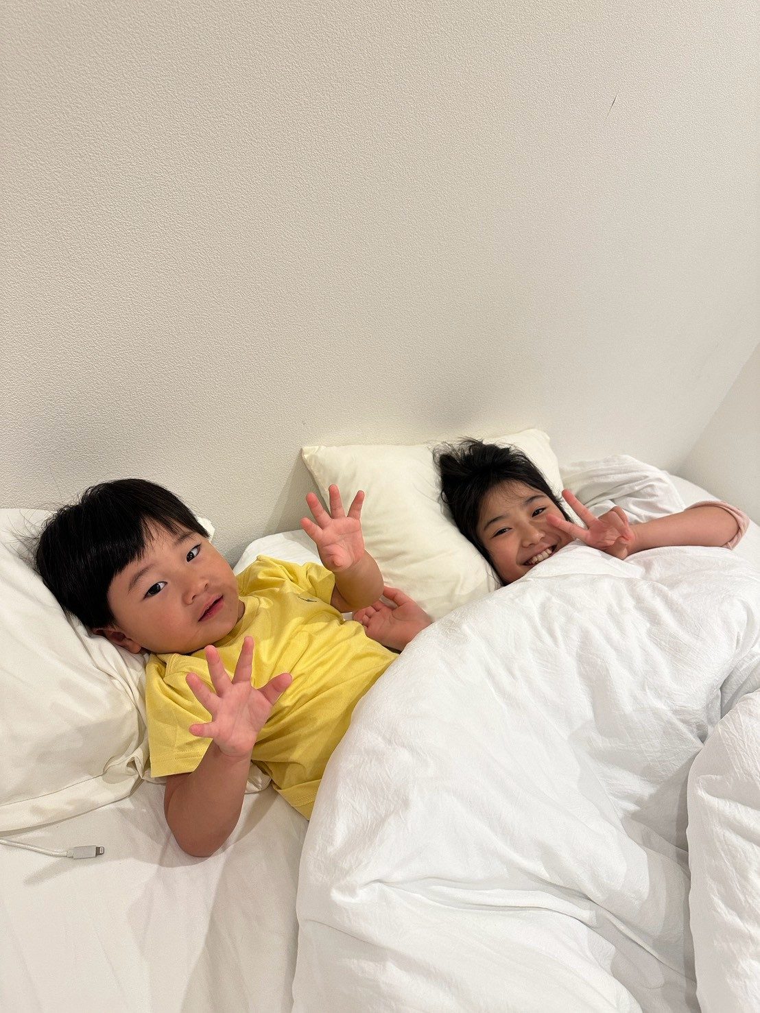 ベッドでピースサインの2人
